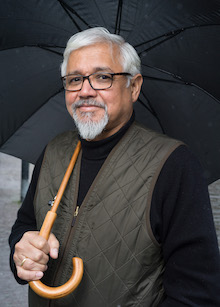 Photo of Amitav Ghosh holding umbrella