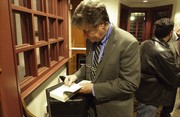 David Maraniss, a Pulitzer Prize-winning author, signs a copy of one of his books after speaking about his approach to writing biographies. 
