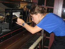 Kaegan Sparks sets up a player piano for the KWH Art exhibit 